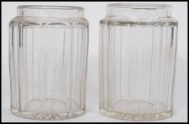 A pair of 19th century facet cut glass jars of cylindrical form having shaped necks believed to be