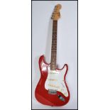 A vintage retro 20th century Encore stratocaster type electric guitar. The shaped red body having