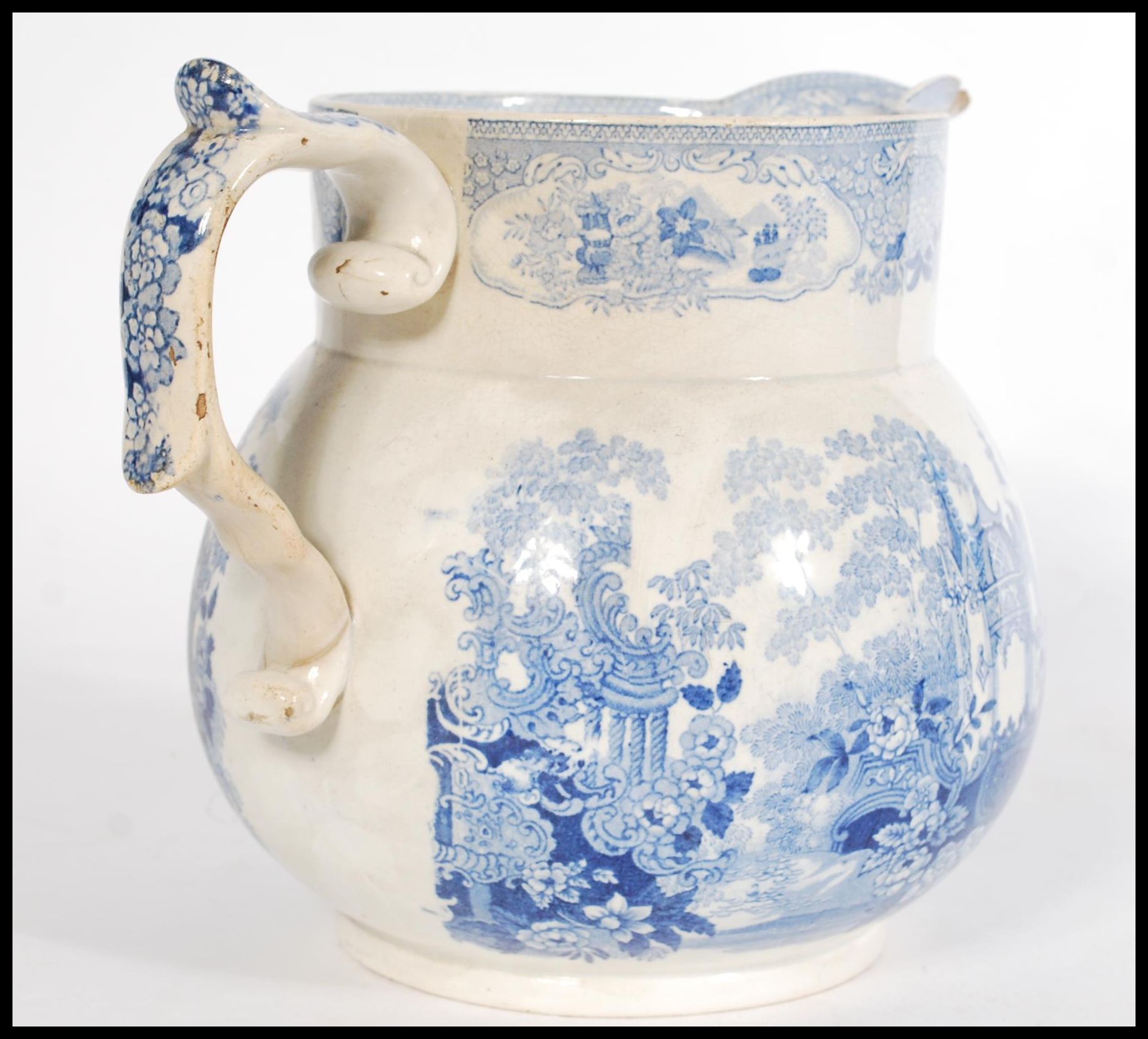 A 19th century Staffordshire Pearlware jug having a scrolled shaped handle with a blue and white - Image 2 of 4