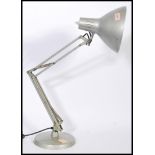 A vintage retro 20th century industrial anglepoise lamp raised on a circular base with pendant.