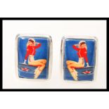 A pair of silver mens cufflinks having square enamel panels depicting the figure of a vintage pin up