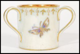 An early 20th century Wedgwood Fairyland Lustre three handles loving marriage cup depicting