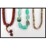 A group of three vintage necklaces to include a large green quartz jade type necklace, a cherry