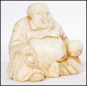 An early 20th century Chinese soapstone carving of a Chinese laughing Buddha carved in a seated