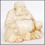 An early 20th century Chinese soapstone carving of a Chinese laughing Buddha carved in a seated