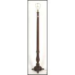 A good 19th century solid mahogany standard lamp of reeded form being raised on terraced base with