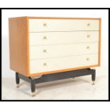 A mid century G-Plan natural oak and white painted chest of drawers. Raised on an ebonised base with