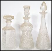 A group of three vintage cut glass decanters to include a thistle shaped decanter with thistle