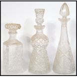 A group of three vintage cut glass decanters to include a thistle shaped decanter with thistle