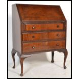 A 1920's mahogany bureau desk being raised on cabriole legs with pad feet supporting a bank of