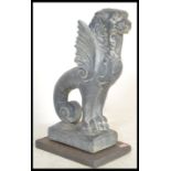 A 20th Century reconstituted stone garden ornament in the form of a Griffin, raised on a slate