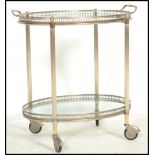 A vintage 20th century silver white metal hostess trolley, with detachable glass bottomed, twin