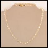 A cultured pearl necklace with a lobster clasp along with a small simulation pearl bracelet.