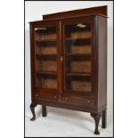 An Edwardian mahogany display cabinet vitrine. The cabinet being raised on shaped cabriole