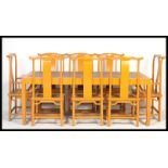 A large Chinese refectory dining table and chairs suite, the large painted table having a rattan