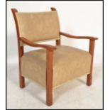 A 20th century Art Deco open framed armchair having shaped elbow rests in oak with overstuffed