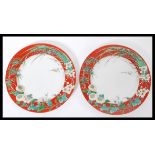 A pair of 19th century Chinese porcelain plates having a red ground with decoration of blossoming