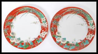 A pair of 19th century Chinese porcelain plates having a red ground with decoration of blossoming
