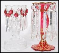 Two 19th century Victorian lustres to include a cranberry glass trumpet form lustre with a