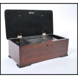 A 19th century rosewood music cylinder box having a hinged lid opening to reveal a glazed panel with