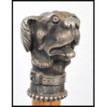 A 20th Century walking cane, the Malacca stick surmounted with a white metal cast figural dog.