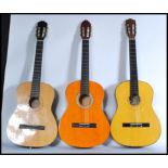 A group of three acoustic six string guitars to include a Burswood, Palencia and another. Average