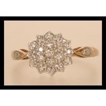 A hallmarked 9ct gold and diamond cluster ring having accent diamonds to shoulders. Size Q. Weight