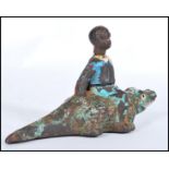 A vintage early 20th century cast iron Black Americana figurine of a boy seated on a crocodile /
