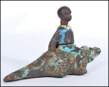 A vintage early 20th century cast iron Black Americana figurine of a boy seated on a crocodile /