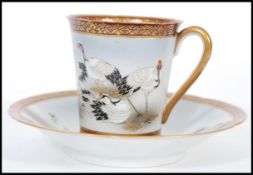 An early 20th century Chinese Kutani ware fine hand painted cup and saucer having detailed gilded