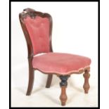A Victorian 19th century mahogany nursing chair being raised on reeded and turned legs with