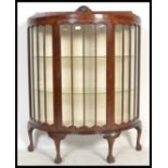 A 1930's mahogany Queen Anne revival demi-lune china display cabinet. Raised on cabriole legs with