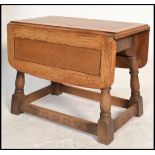 A vintage 20th century Ercol carved oak drop end leaf coffin / coffee table raised on turned legs.
