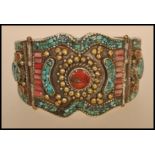 A Chinese / Himalayan silver white metal bangle bracelet set with coral cabochons, turquoise and