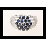A stamped 14ct white gold sapphire and diamond cluster ring having a split shank design. Size N.5.