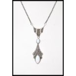 A silver Art Deco style pendant necklace set with two opals and marcasite accent stones. Weight 8.