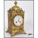 A 19th century French gilt brass mantel clock having grotesque face masks and pineapple finials. The