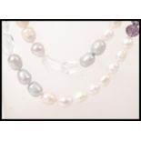 A long ladies fresh water pearl necklace having faceted aqua marine and amethyst spacers. Measures