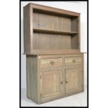 An early 20th century Welsh dresser being raised on a plinth base with a series of cupboards and
