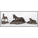 A collection of three bronzed effect sculptures modelled as horses / foals, to include a recumbent