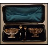 A pair of 19th Century hallmarked silver salt cellars with oval bases and fluted decoration, with