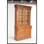 A Victorian oak library bookcase cupboard cabinet raised on a plinth base having twin door