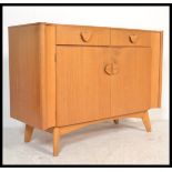 A mid century oak sideboard being raised on tapering legs with short drawers over cupboards beneath.