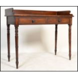 A Victorian mahogany writing table desk being raised on turned legs with twin drawers to the
