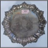 A hallmarked silver 19th century Victorian salver tray raised on scalloped feet with scrolled and