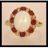 A marked 14ct gold opal cluster ring having a central opal panel with a halo of orange stones.
