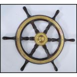 An early 20th century stained teak and brass bound ships wheel,with notation to the verso reading