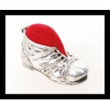 A sterling silver pincushion in the form of a boot. Weight 15.9g.