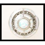 A silver Art Deco style ring having concentric circular opal panels to the head with inset