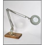 A vintage 20th Century industrial illuminated magnifying optic, raised on an standing anglepoise